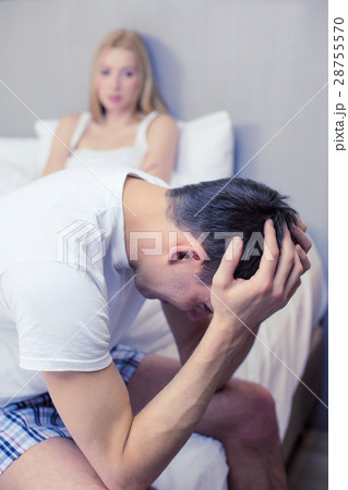 man sitting on the bed with woman on the back 28755570