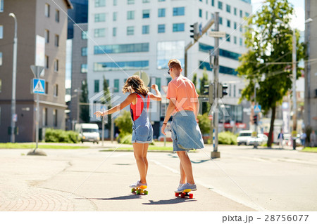 teenage couple riding skateboards on city street teenage couple riding skateboards on city street 28756077