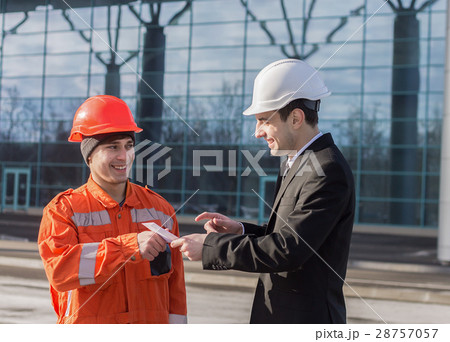 boss giving salary in an envelope and smiling boss giving salary in an envelope and smiling 28757057
