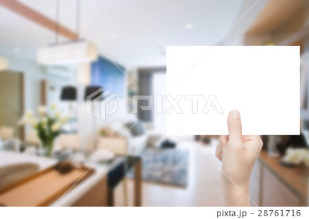 hand holding blank paper with interior background hand holding blank paper with interior background 28761716