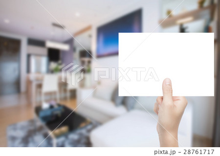 hand holding blank paper with interior background hand holding blank paper with interior background 28761717