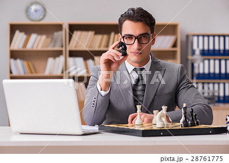 Young businessman playing chess in the office 28761775