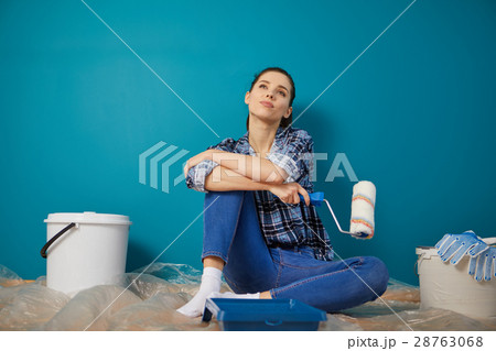 Portrait of female painter near wall before painting. 28763068