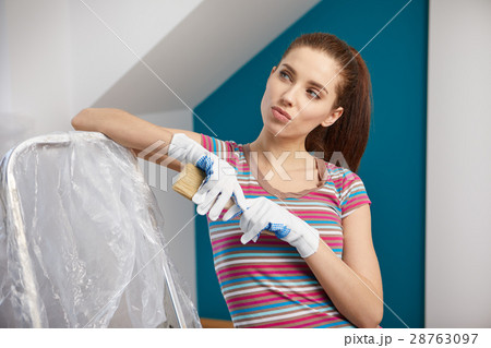 Portrait of female painter near wall before painting. Portrait of female painter near wall before painting. 28763097