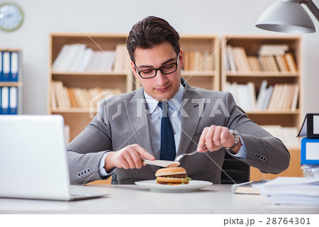 Hungry funny businessman eating junk food sandwich 28764301