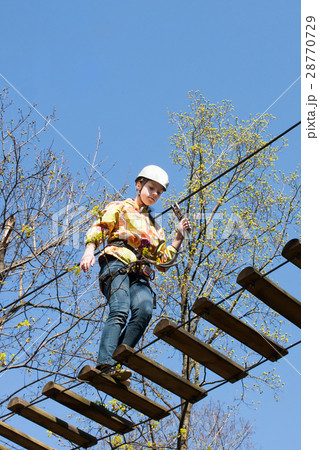 the girl climbs obstacles of rope park 28770729