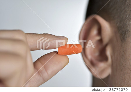 man putting on an earplug 28772070