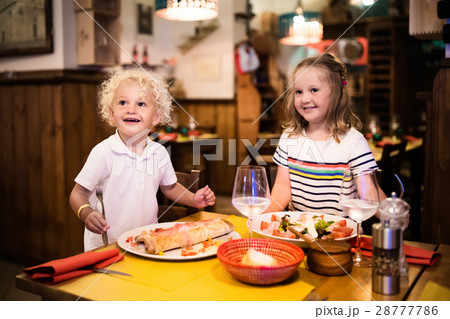 Kids eating pizza in Italian restaurant 28777786