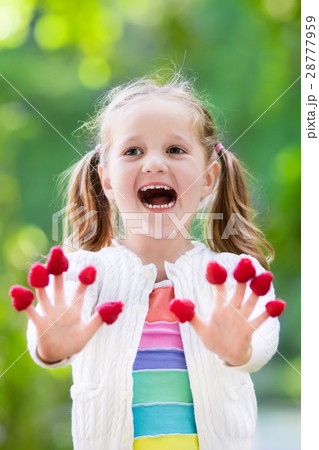 Child picking and eating raspberry in summer Child picking and eating raspberry in summer 28777959