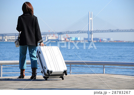 港で白いスーツケースを持つ女性旅行者 28783267