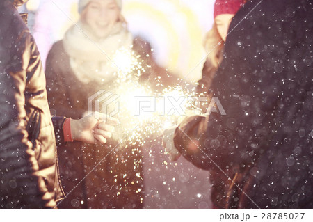 group of young people with sparklers Christmas party winter snow city 28785027
