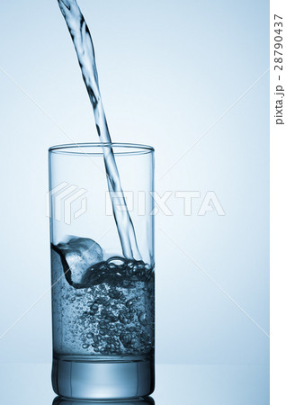 water pouring into glass on blue background water pouring into glass on blue background 28790437