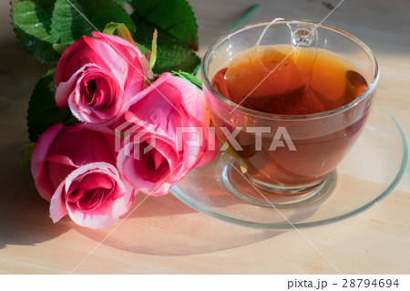 Rose with hot tea on a wooden table. Rose with hot tea on a wooden table. 28794694