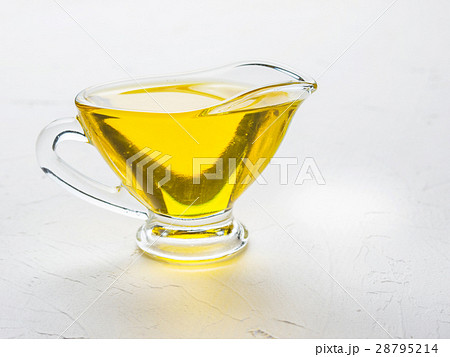 Olive oil in gravy boat on white concrete 28795214