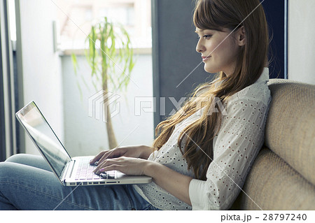 ソファーでパソコンを使う20代女性 ソファーでパソコンを使う20代女性 28797240