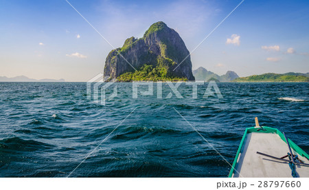 Banca Boat approaching Huge Rocky Island on Windy Banca Boat approaching Huge Rocky Island on Windy 28797660