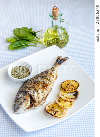 Grilled dorada fish with lemon and spinach 28806240
