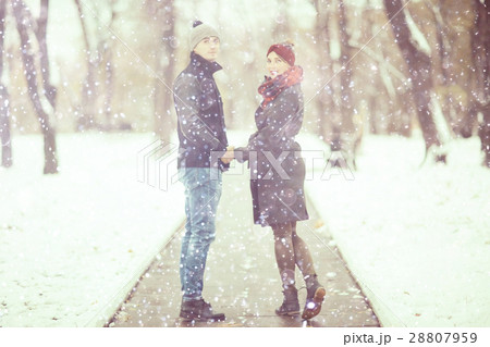 young man and woman in the snow in a city park couple winter young man and woman in the snow in a city park couple winter 28807959