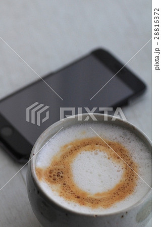 家で淹れたフワフワミルクのカプチーノとスマホ 28816372