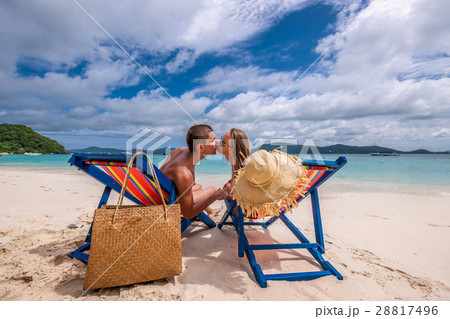Couple kissing on tropical beach in loungers 28817496