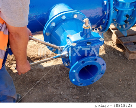Worker hands screwing  nuts on dring water piping. 28818528