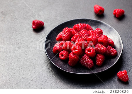 Fresh raspberries on a black bowl Slate background Fresh raspberries on a black bowl Slate background 28820326