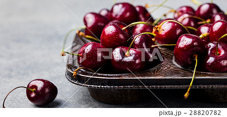 Black cherries in vintage dish. Stone background. 28820782