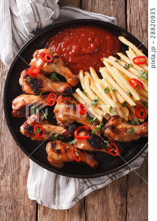 Spicy BBQ chicken wings with french fries 28820935