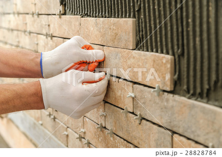 Installing the tiles on the wall. 28828784
