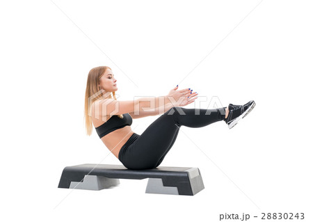 Pretty fitness trainer exercising on step platform Pretty fitness trainer exercising on step platform 28830243