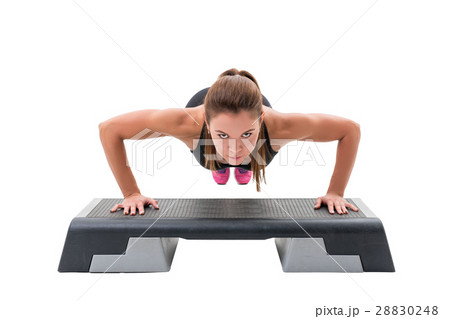 Young fitness trainer exercising on step platform Young fitness trainer exercising on step platform 28830248