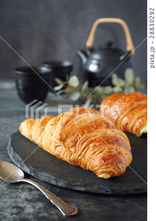 Two fresh croissants and teapot 28830292