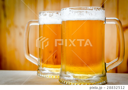 Two beer mugs on the wooden background Two beer mugs on the wooden background 28832512
