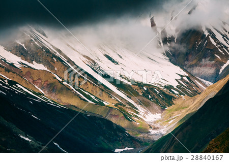 Clouds fly low over rocks. Mountain peaks covered 28840167