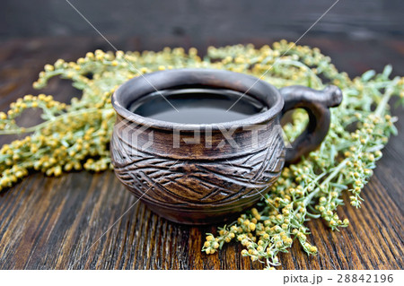 Tea with wormwood in cup on board 28842196