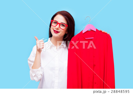 beautiful young woman with shirt on hanger standing in front of beautiful young woman with shirt on hanger standing in front of 28848595