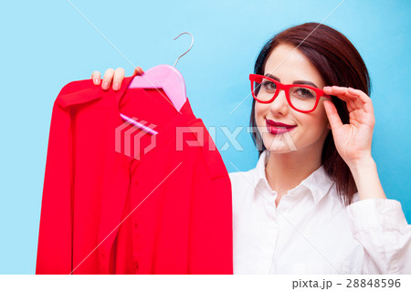 beautiful young woman with shirt on hanger standing in front of 28848596