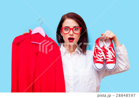 beautiful young woman with shirt on hanger and gumshoes standing beautiful young woman with shirt on hanger and gumshoes standing 28848597