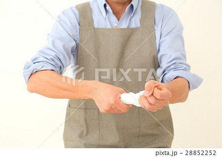 雑巾絞りをする男性 白バックの写真素材