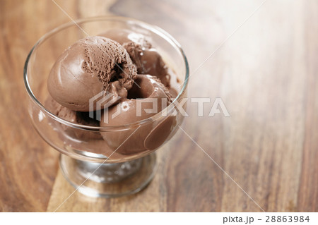 chocolate ice cream in glass bowl on wooden table 28863984