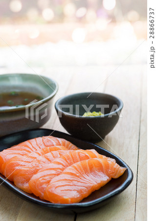 Sliced raw salmon on black plate with background Sliced raw salmon on black plate with background 28866737