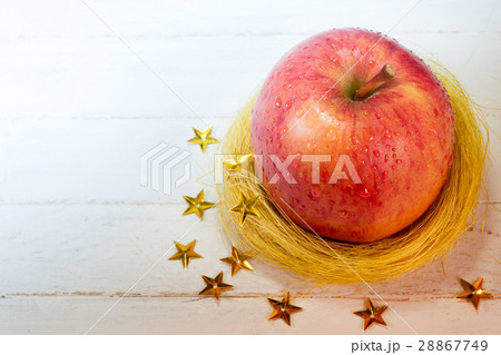 Fresh apple in golden nest and stars on wood 28867749