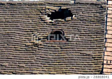 Old damaged tiled roof with a hole on the roof  28868041