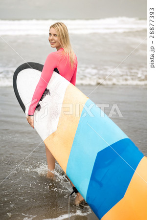 Girl with surfboard on beach Girl with surfboard on beach 28877393