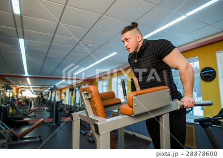 Focused man doing dips in the gym 28878600