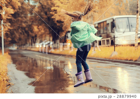 girl jumping in the puddles in the autumn rain 28879940