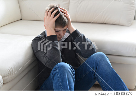 Upset teenager 13 years sitting near couch and 28888870