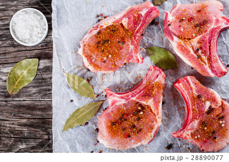Raw fresh pork chops on a white parchment paper Raw fresh pork chops on a white parchment paper 28890077