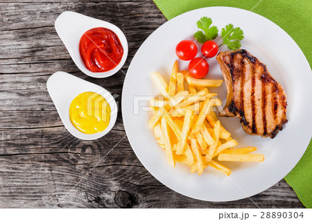 grilled pork chops on a white dish, top view 28890304