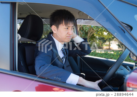 運転中イライラする男性ビジネスマンの写真素材